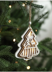 Close-up of a lit wooden Christmas star ornament hanging on a festive tree branch