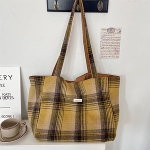 Detail of yellow plaid tote bag with Sorakka label showing premium woven fabric texture
