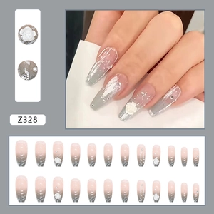 Press-on nails featuring grey-pink gradient with 3D white camellia flowers and rhinestones