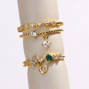 Détail macro d'un ensemble de trois bagues dorées avec pendentifs lune et pierres opale