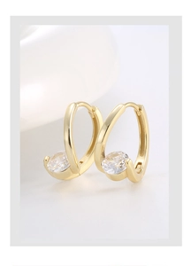 Detail view of gold-plated U-shaped earrings with sparkling round zircon stone