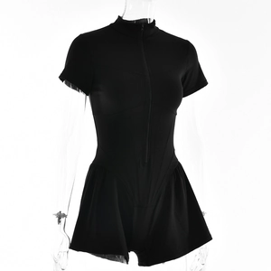 Close-up of black short sleeve romper featuring front zipper and flared shorts hem