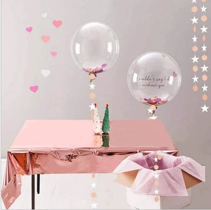 Detail of rose gold foil tablecloth with confetti balloons and wedding party decor