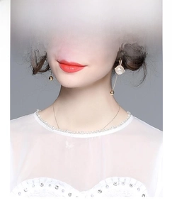 Close-up of elegant gold chain jewelry set with white pearls on a female model