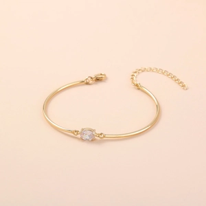 Detail of adjustable gold bracelet featuring a diamond-shaped zircon inlay and lobster clasp