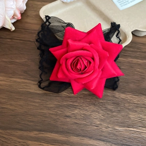 Détail d'une rose en tissu rouge foncé avec une élégante bordure en dentelle noire