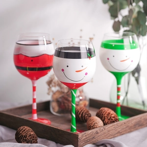 Three hand-painted Christmas wine glasses featuring Santa, Snowman and Elf motifs