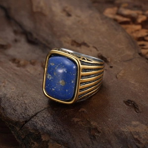 Detailed view of vintage men's ring with blue lapis stone on rustic dark wood background