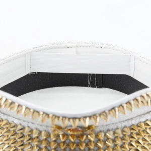 Detailed view of white punk captain hat with gold studs and interior elastic band