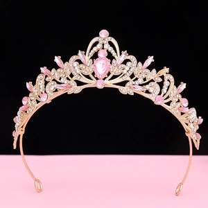 Detail of rose gold crown with pink water-drop crystal and intricate rhinestone floral patterns