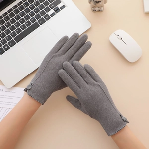 Detail view of gray winter gloves featuring a classic checkered bow and soft warm fabric