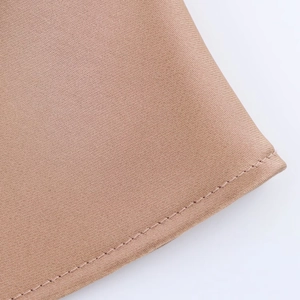 Detail shot of camel satin fabric showing diagonal twill texture and neat stitching