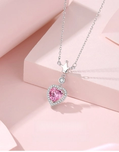 Macro shot of S925 sterling silver heart crown necklace with pink center stone