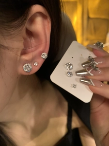 Detailed comparison of various sizes of round zircon earrings on a model and card display