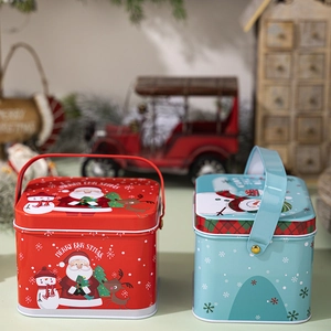 Detailed view of red and light blue Christmas tin boxes with handles and festive patterns