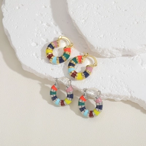 Minimalist C-shaped hoop earrings with colorful enamel dripping on white stone background
