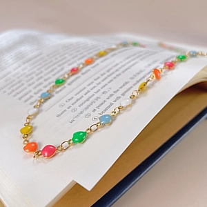 Vue détaillée des pendentifs cœur arc-en-ciel sur une fine chaîne dorée élégante