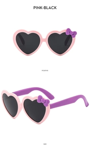 Detailed view of pink heart sunglasses with purple bow accents and black lenses