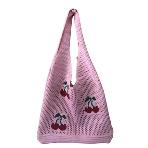Detail view of pink knitted tote bag featuring a cute cherry pattern embroidery