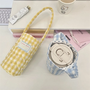 Detailed macro view of quilted checkered cup bags with soft cotton padding and handles