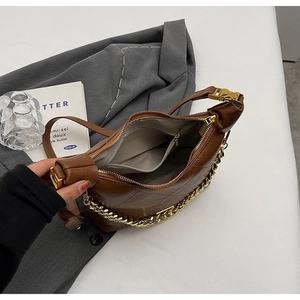 Interior view of brown quilted bag showing main compartment and zippered pocket