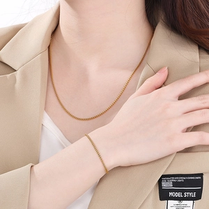 Polished gold stainless steel link necklace and matching bracelet set on female model