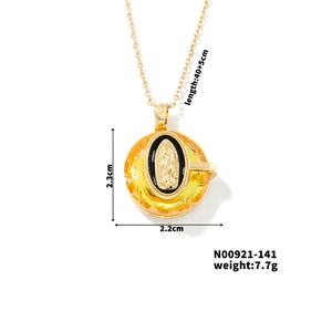 Detail view of gold crystal pendant necklace with Virgin Mary icon and size specs