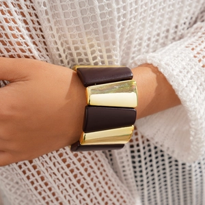 Macro detail of elastic chunky bracelet with gold and dark brown geometric acrylic segments