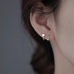 Minimalist sterling silver star stud and bead hoop earrings set on model ear