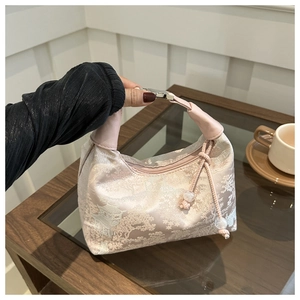 Detail of pink jacquard handbag featuring traditional Chinese landscape embroidery and beads