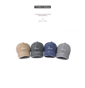 Detail view of washed cotton baseball caps with Groom embroidery in four retro colors