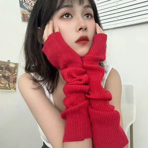 Detail of red knitted arm sleeves with ribbed texture on a model in a bright setting