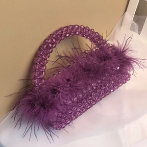 Detailed view of dark purple beaded handbag with plush ostrich feathers and clear beads