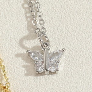 Macro shot of silver butterfly pendant with zircon wings on a fine link chain