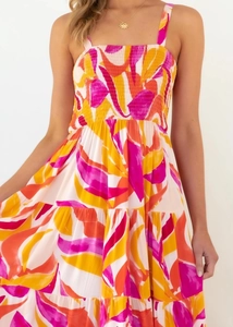 Detail of bohemian tiered ruffled hemline and vibrant multi-color print on summer dress