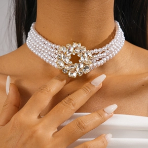 Close-up of elegant multilayer pearl choker necklace with sparkling crystal flower center