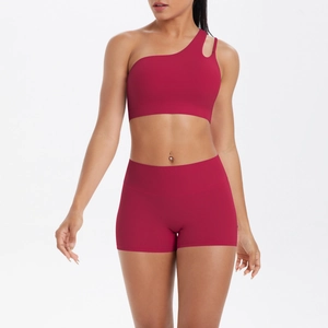 Detail of burgundy one-shoulder sports bra with cutout strap and high-waisted gym shorts