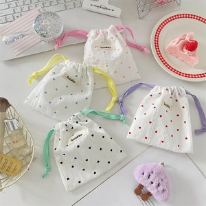 Set of four cute drawstring pouches with colorful heart patterns for small accessories