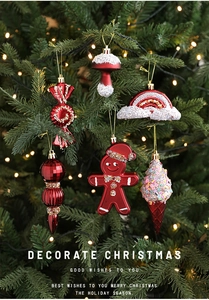 Detailed view of gingerbread and candy ornaments on a green Christmas tree with warm lights