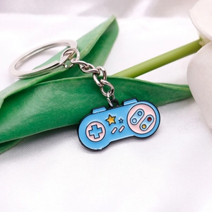 Detail view of blue pixel game controller keychain with enamel heart and star details