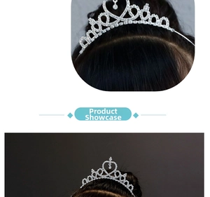 Detailed view of silver kids tiara with heart motifs and hanging crystal on dark hair