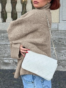 Sac à chaîne en cuir matelassé blanc élégant avec un pull marron et un jean en denim bleu