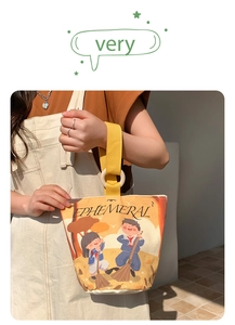 Detail of yellow canvas bucket bag with artistic illustration and wooden ring handle