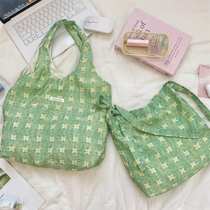 Close-up of green floral canvas tote bag with Sorakka brand tag and natural fabric texture
