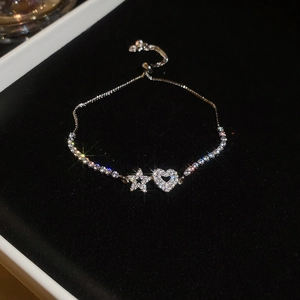 Detailed macro view of silver hollow heart and star bracelet with sparkling zircon stones