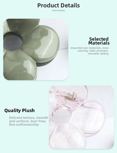Detail display of flower hair claws in olive green and translucent pink acrylic finish