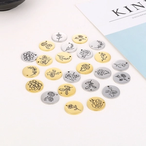 Detail of round stainless steel birthday flower pendants in gold and silver finishes