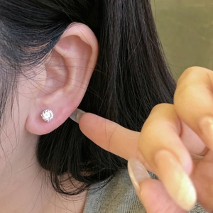Macro shot of a minimalist S925 sterling silver stud earring with 5A zircon on an ear