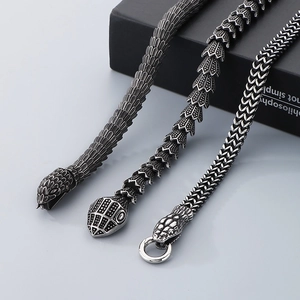 Macro detail of punk style snake head necklaces in retro distressed stainless steel