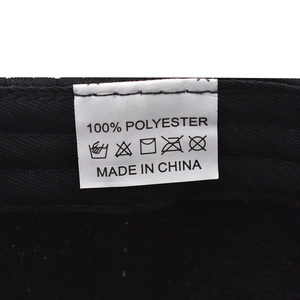 Detail of the internal wash label showing 100% polyester material on the black baseball cap